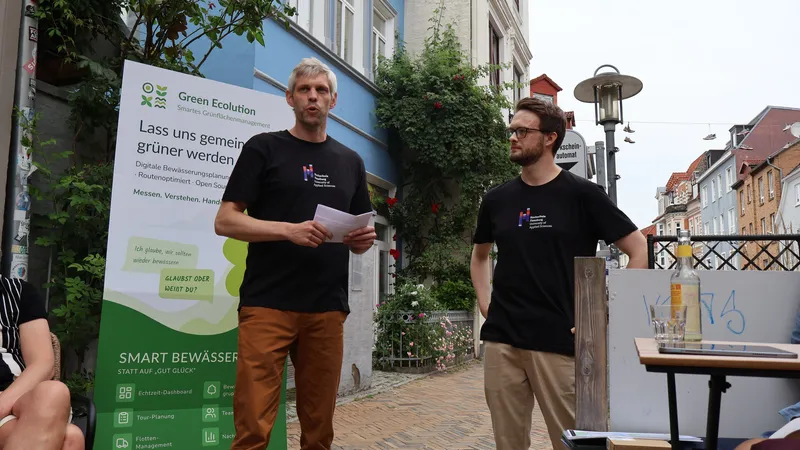 Simon Olberding and Cedrik Hoffmann presenting Green Ecolution in front of the roll-up on Flensburg's Norderstraße
