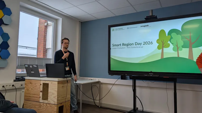 Presentation in front of a large screen showing the Smart Region Day 2026 title slide of Green Ecolution and Amt Süderbrarup