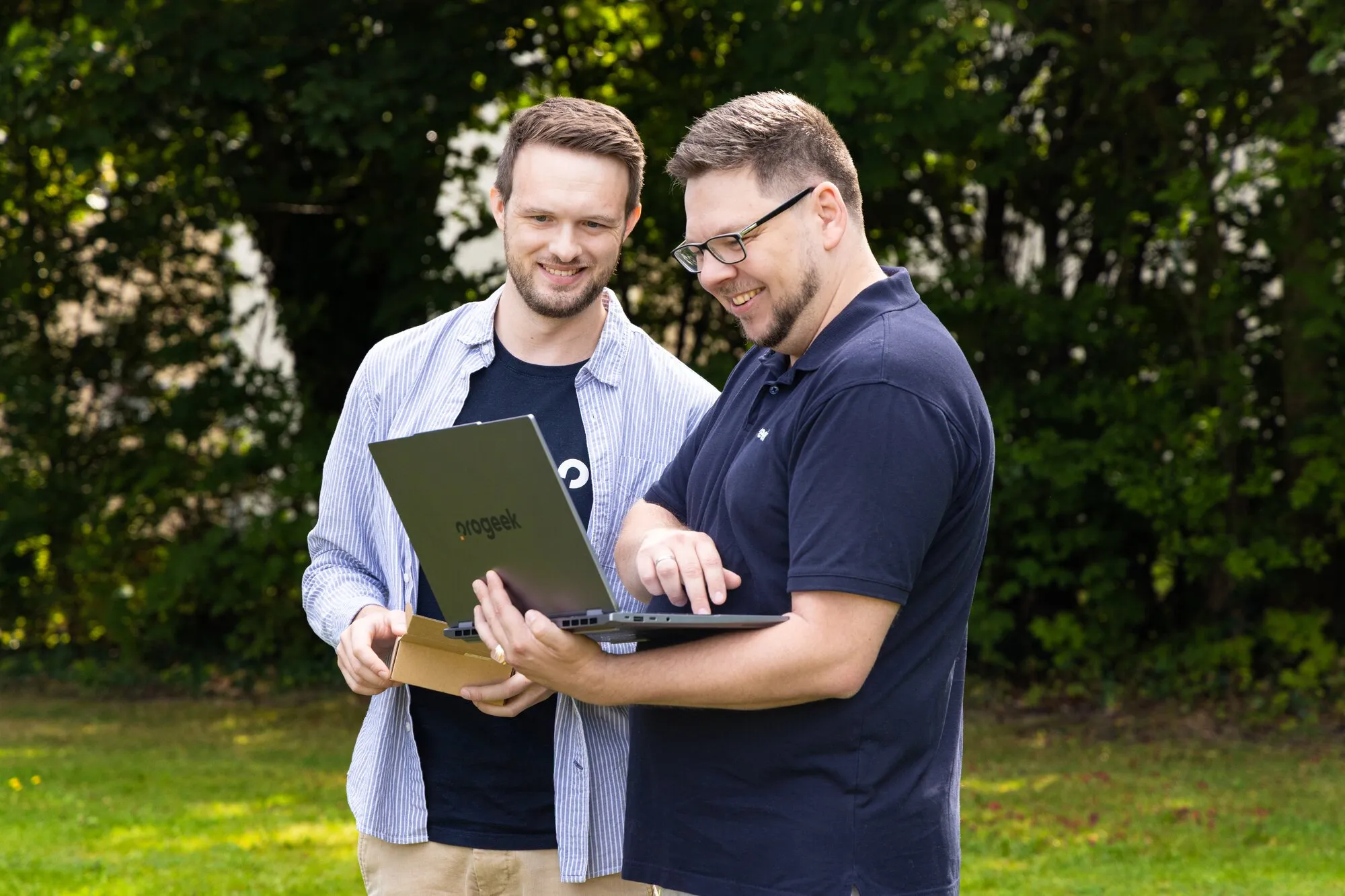 Two PROGEEK staff members looking at something on a laptop together.